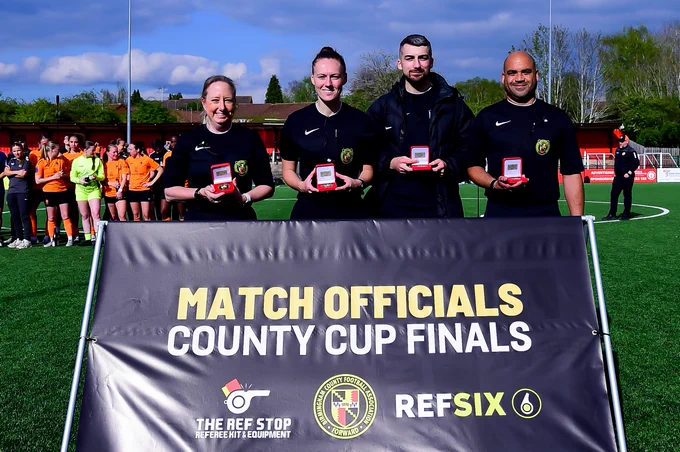 BCFA Match Officials pose with their medals at the end of the match.