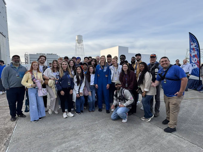 A group of NASA Social participants poses for a photo with NASA astronaut Nichole Ayers at the NASA Michoud Assembly Facility.