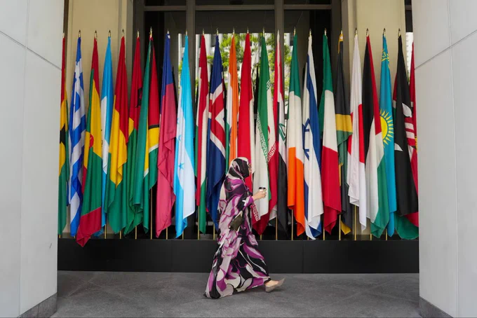 Mulher caminha diante de uma fileira de bandeiras no prédio do FMI durante as reuniões de primavera do FMI/Banco Mundial de 2026, em Washington, D.C., EUA.
Foto: Reuters/Ken Cedeno