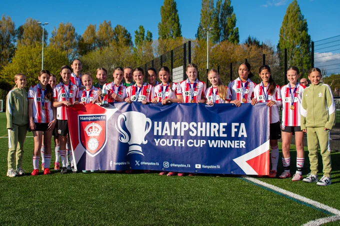 Southampton FC Women's Under-14s players celebrate with Hampshire FA Under-14 Girls Cup trophy and medals