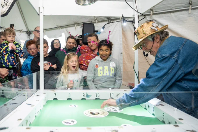 Tom Turpin organizing the cockroach races with kids watching.