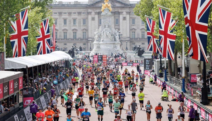A shot from the finish line at pall mall with runners in their running vests making their way to the finish