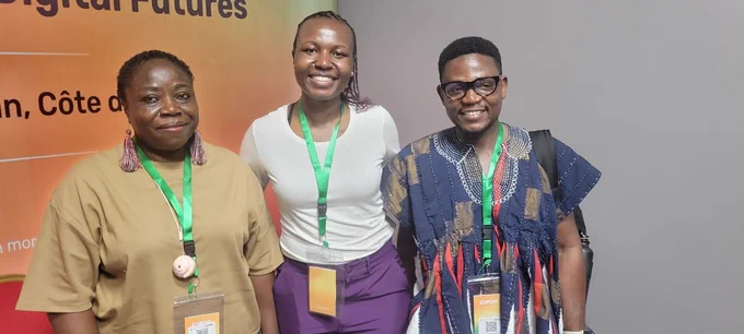 three Black professionals standing next to each other smiling