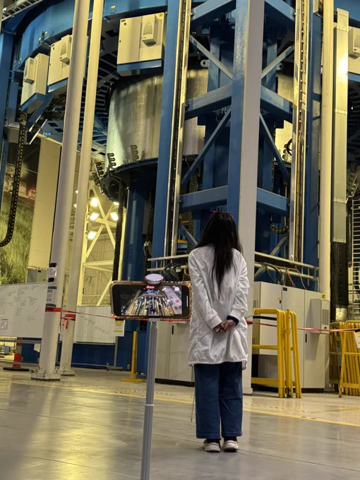 A digital creator takes a photo of themselves at the NASA Michoud Assembly Facility.