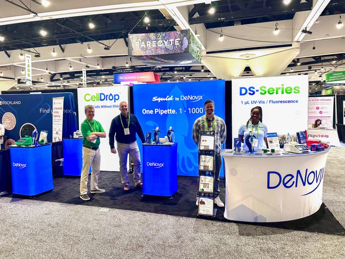 The DeNovix team smiles in front of the DeNovix booth at AACR 2026