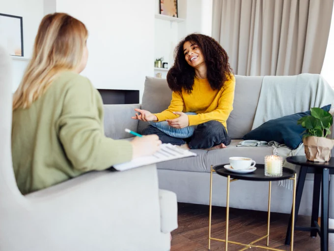A health and wellness professional sits with a client and smiles