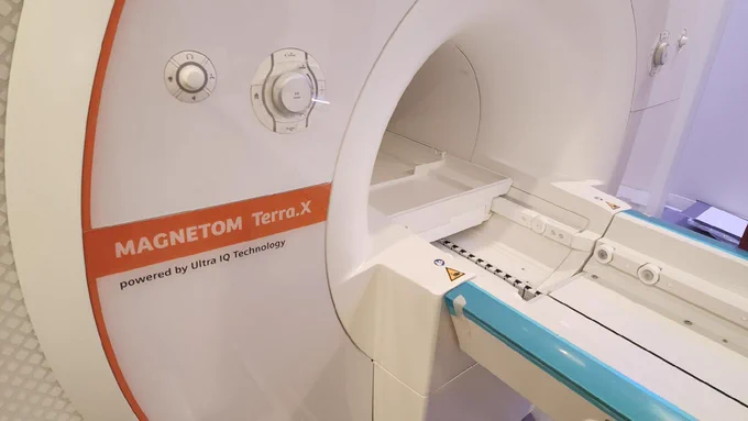 A closer photo of the University of South Carolina's new 7-Tesla MRI scanner. The view shows the "donut hole" opening in the scanner, where patients slide in for imaging. Visible are two round dials and the scanner's name "[Siemens Healthineers] MAGNETOM Terra.X, powered by Ultra IQ Technology."