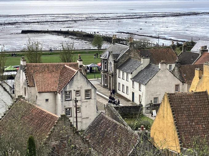 View from above of Culross and its ‘Palace’ in yellow,  a pier and sea water.