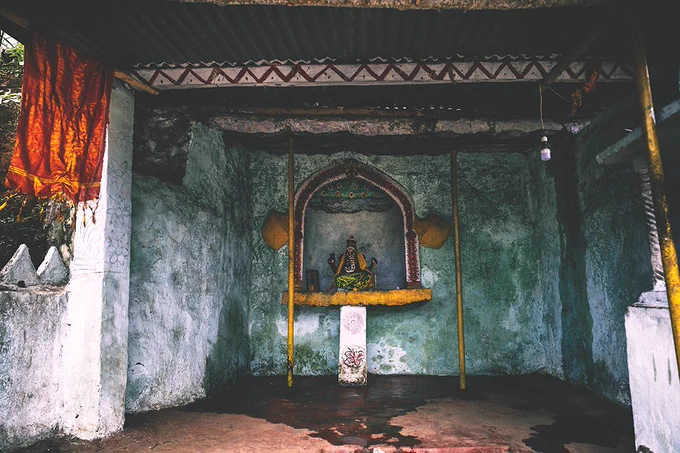 A rough and simple Hindu shrine with a small statue of Ganesh on an altar against the far wall.
