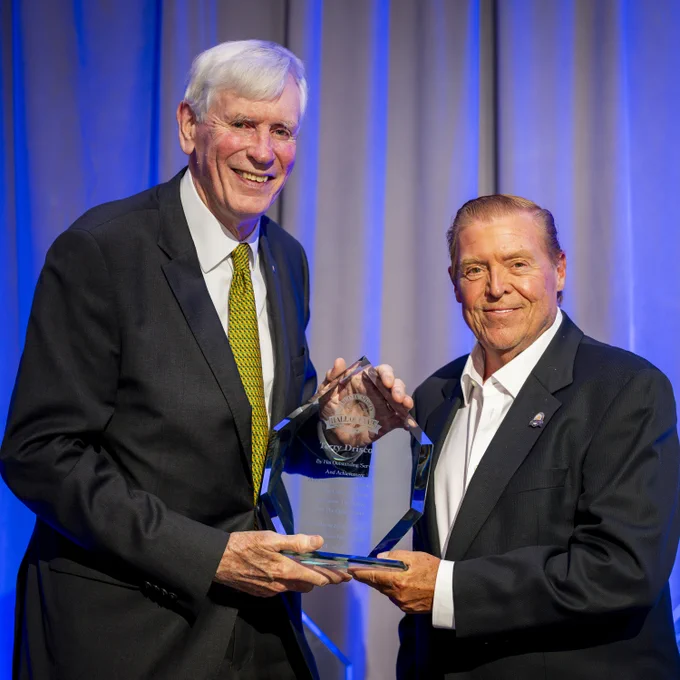 Former William & Mary Athletic Director Terry Driscoll (left) accepts a crystal trophy honoring his induction in the Virginia Sports Hall of Fame from Bruce Rader (right) during the 53rd induction class at the Hilton Richmond Hotel Short Pump on April 25, 2026. 