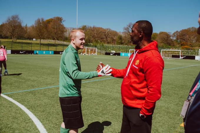 Andy Cole shakes hands with one of the players.