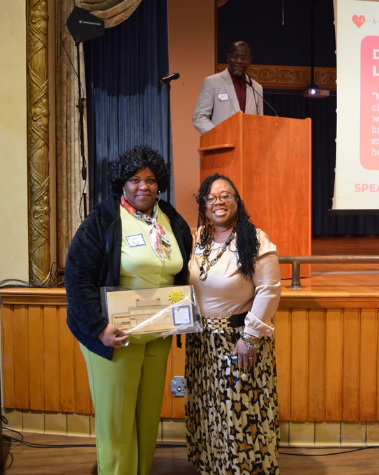 Michele Boyd being given the Dr. Constantino Fernandez Leadership and Advocacy Award by Dr. Mary Bisbee-Burrows, Chair of the African American Health Coalition.