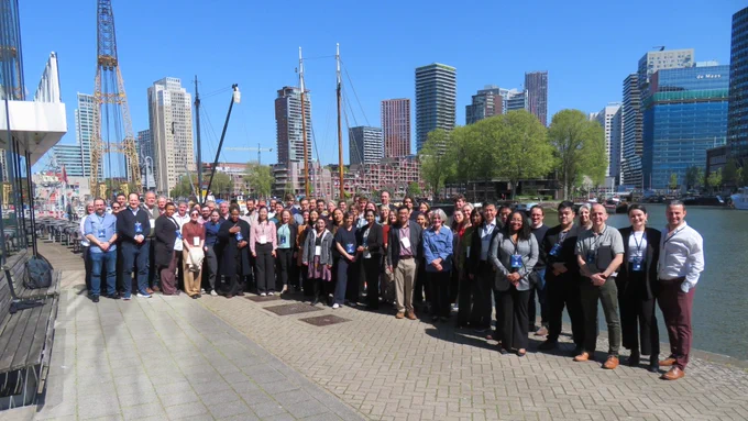 Photograph of members of the MUSICC consortium stood outside, in front of the Rotterdam city skyline on a sunny day.