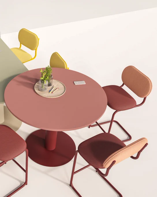 A poseur height table in terracotta hues surrounded by cantilever high stools in coordinating shades.