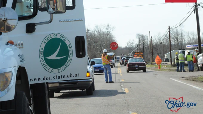 A flagger controls traffic at a road construction site.