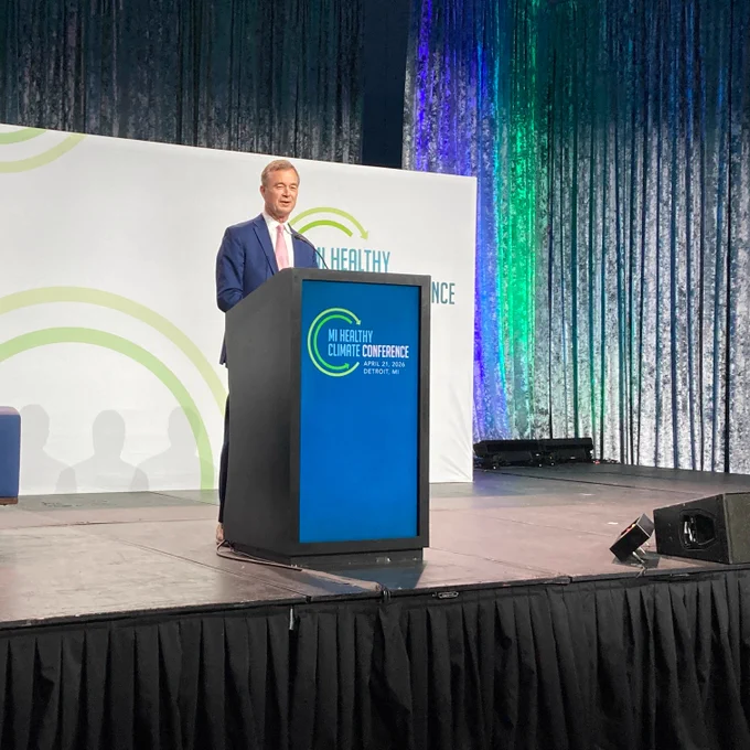 EGLE Director Phil Roos stands a podium speaking to audience at the MI Healthy Climate Conference.