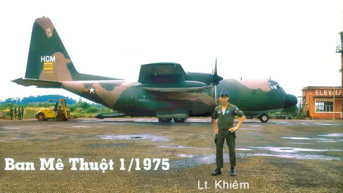 Pham Quang Khiêm stands in front of a military aircraft painted with camouflage and a marked 'HCM.' The background shows other aircraft parts and a building.