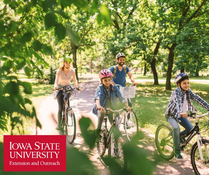 family riding bikes together on a path