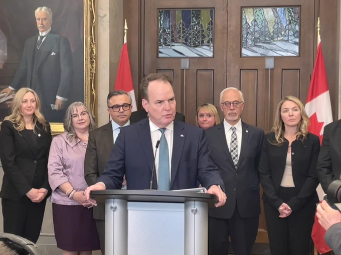 Minister MacKinnon speaking at a podium on Parliament Hill. 
