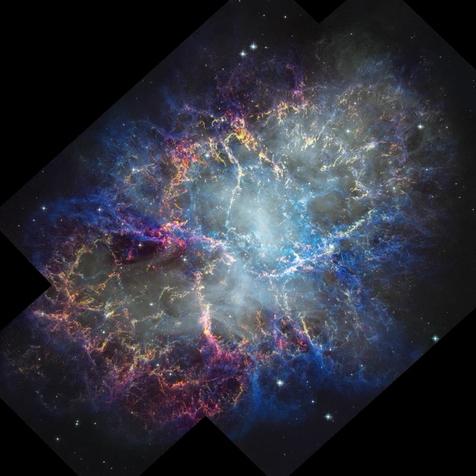 A detailed image of the Crab Nebula with a bright bluish center and web like filaments in blue, purple, and orange spread across a dark background, shown in a mosaic shaped frame.