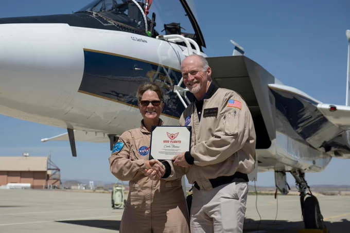 Troy Asher, acting center director, presents NASA aerial photographer Carla Thomas with an award commemorating her 1,000th flight at NASA\u2019s Armstrong Flight Research Center in Edwards, California, on Monday, April 20, 2026. Credit: NASA/Ryan Kline