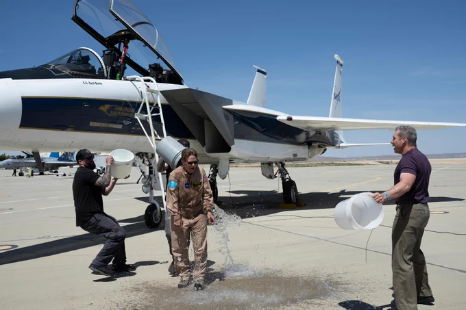 F-15 crew chief Zack Burke, left, and X-59 mechanic Jamie Trescott, behind NASA aerial photographer Carla Thomas, splash buckets of ice water on her in celebration of a 1,000th flight at NASA\u2019s Armstrong Flight Research Center in Edwards, California, on Monday, April 20, 2026. Credit: NASA/Carla Escamilla