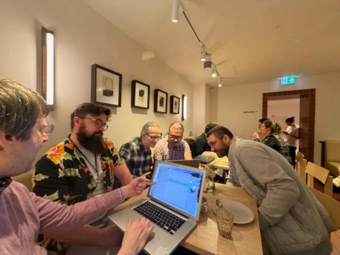 Photo of the left hand side of the room with attendees showing their work on MacBooks.