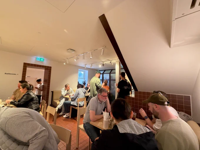 Photo of the right hand side of the room with attendees engaged in conversation.