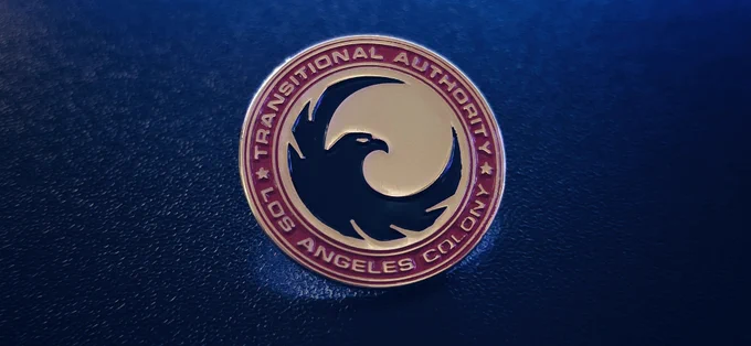 Pin from the 2016 TV Show 'Colony.' The Transitional Authority, is an occupying organization that controls Los Angeles. Its very apt with whats going on in the world today. Screen used prop.

Image: Michael Knight.
@michaelmknight | linktr.ee/michaelmknight.