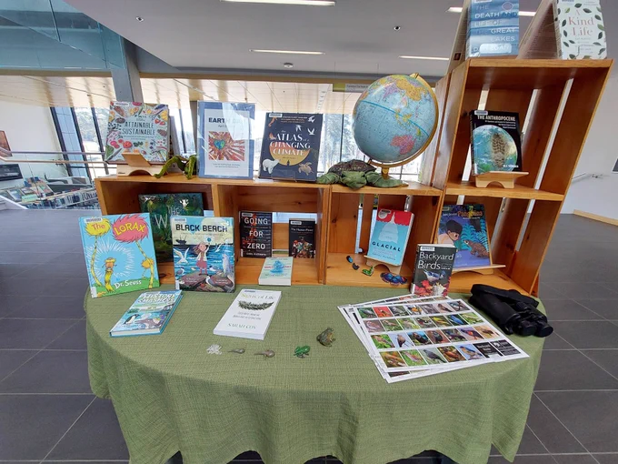 Display table filled with books, puppets, Kits, a globe, binoculars, and more that can be borrowed from the collection.