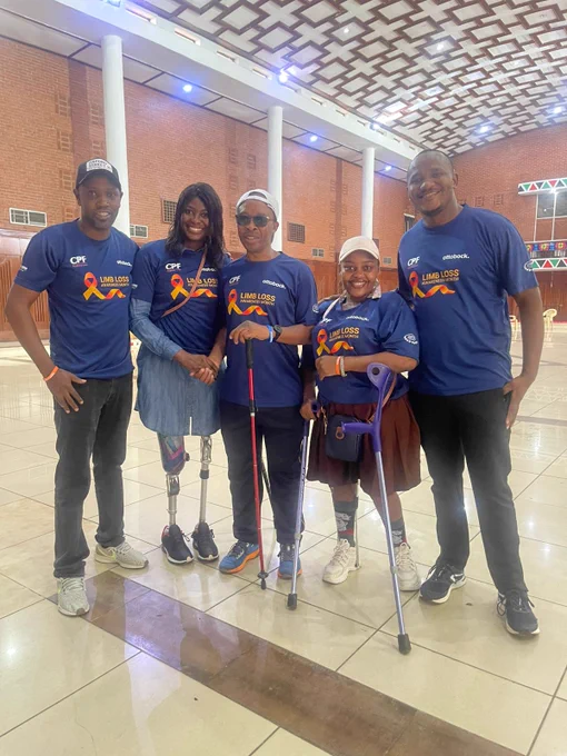 Asiya Mohamed takes a photo with our team and the legendary Henry Wanyoike