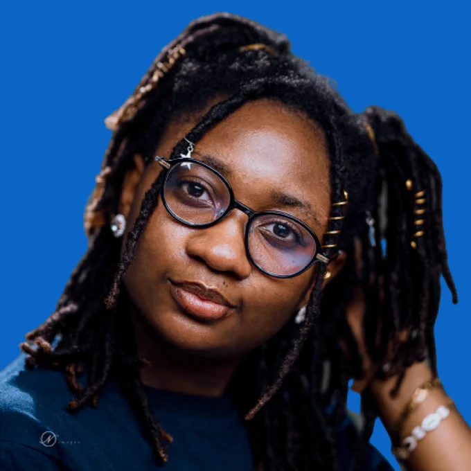 Dada Designer - spectacled Nigerian woman in her twenties with accessorised locs.