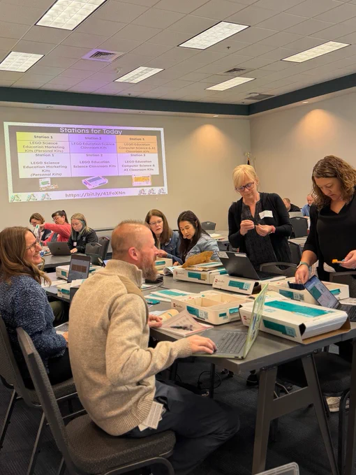 Groups of adults sitting around a table looking through LEGO education kits.