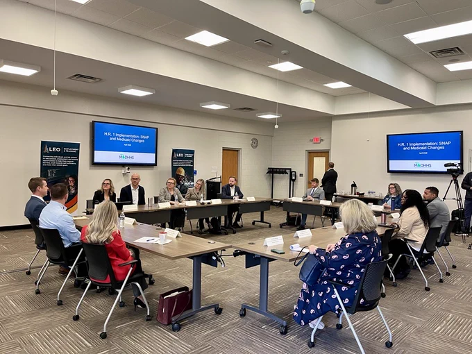 Several stakeholders meeting in a conference room setting to discuss H.R. 1's impact to benefits.