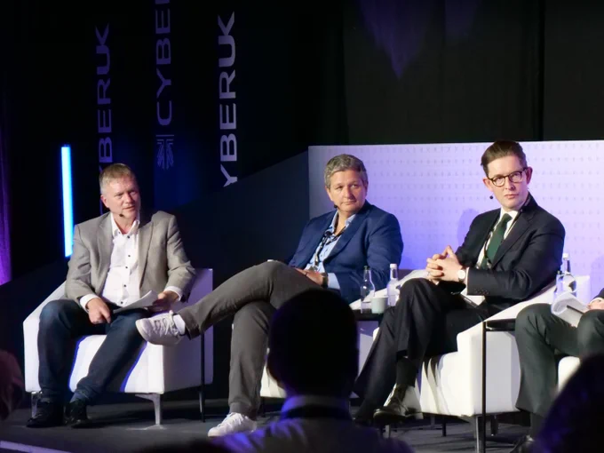 Cyber UK speakers sitting on chairs next to each other on the stage. 