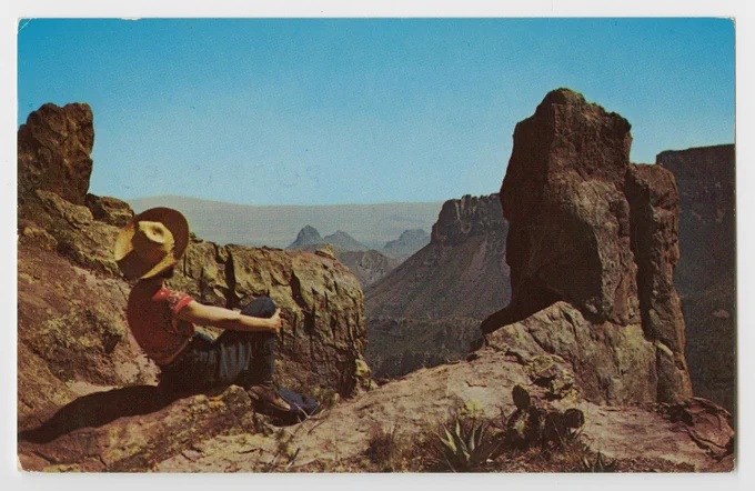 color photo of a woman in a hat, overlooking a canyon