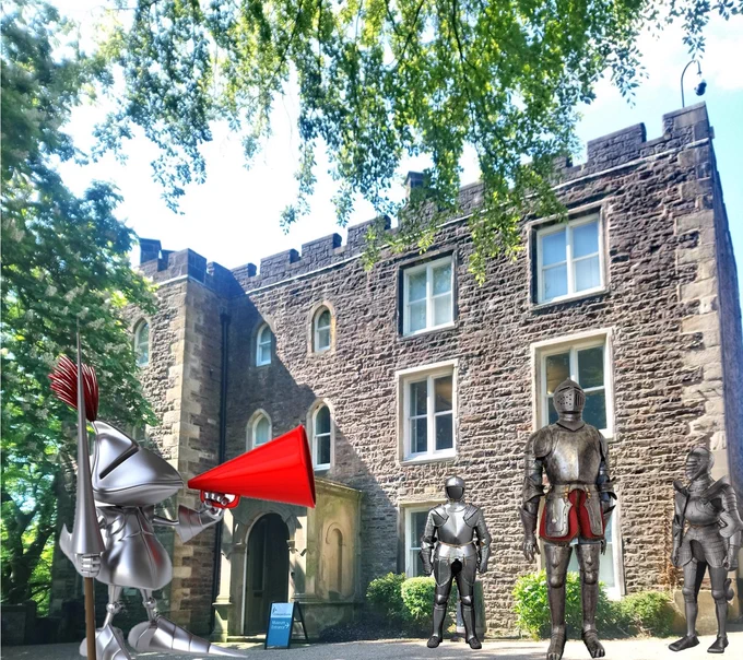 Four knights standing outside Clitheroe Castle Museum.  One with a loud hailer.