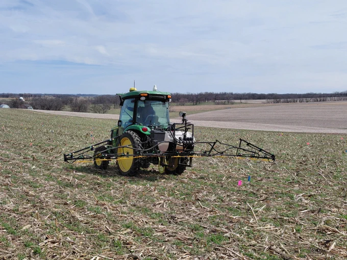 A tractor with a sprayer attached terminates cover crops in a field.