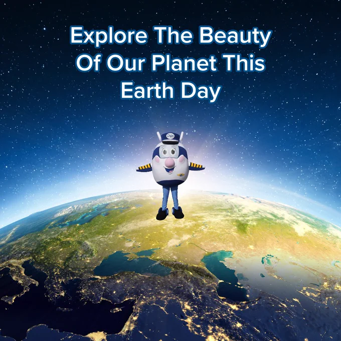 An Earth Day graphic featuring Gracie standing atop a view of Earth from space. The text above reads, "Explore The Beauty Of Our Planet This Earth Day." The planet shows city lights glowing at night across the earth against a starry sky background.