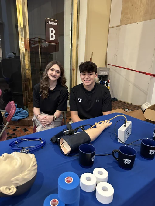 Lucy O'Neal and Lucas Dzikowski in front of their sports medicine display.