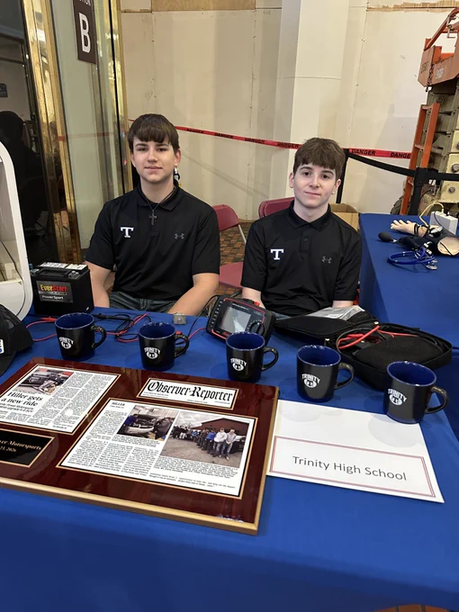 Two Trinity students in front of their power motor sports display.