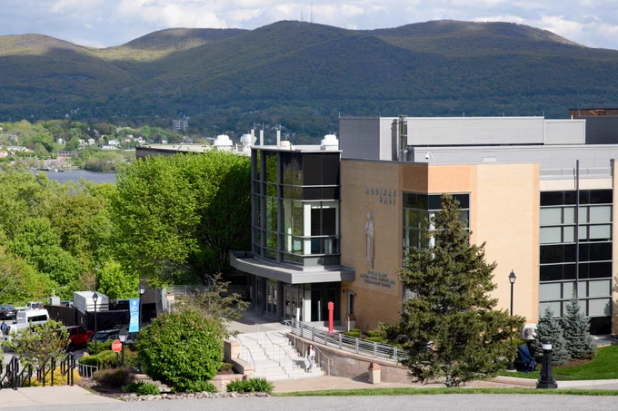 Summertime scene at Mount Saint Mary College. Aquinas Hall is the main focus with mountains towering in the background.