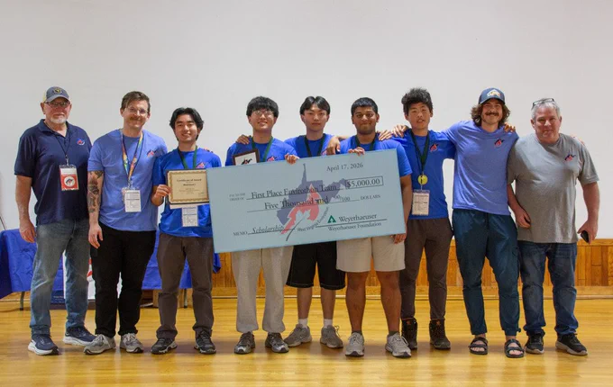People standing in a group holding a check