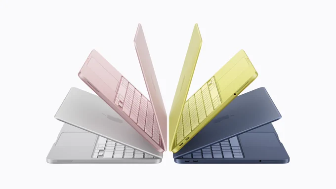 MacBook Neo in silver, blush, citrus, and indigo, arranged back to back in a fan pattern, each slightly open.