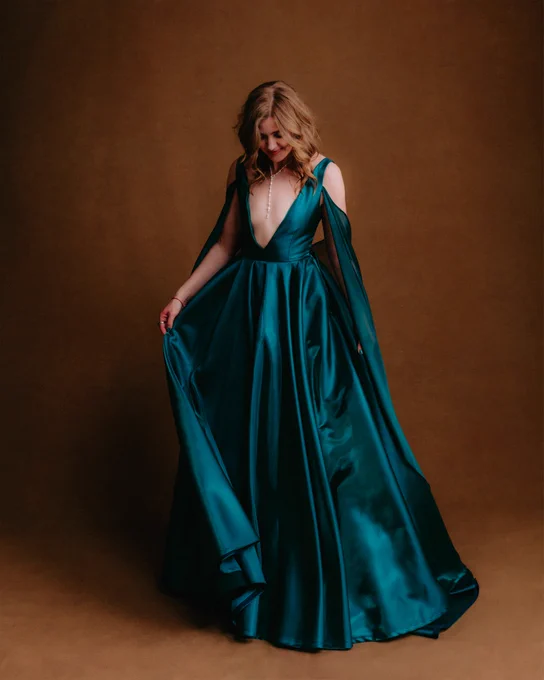 Jennifer English looks towards the floor as she poses in her turqoise floor-length gown.