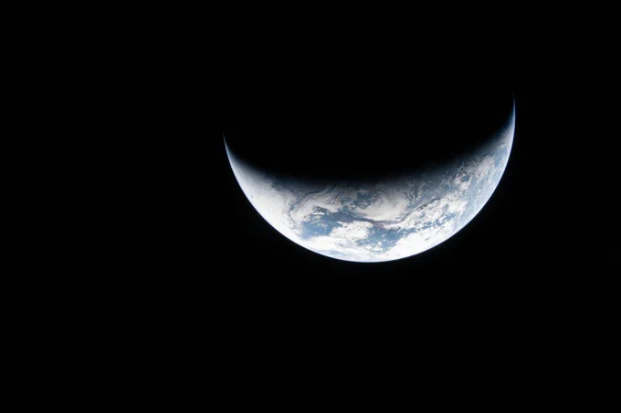 Image of crescent Earth. Against the blackness of space, the shining blue and white of Earth appears like a smile. Credit: NASA