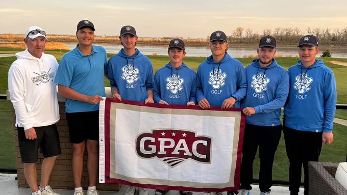 The 2025-26 DWU Men's Golf team lined up together and holding a GPAC flag, photo by the Great Plains Athletic Conference