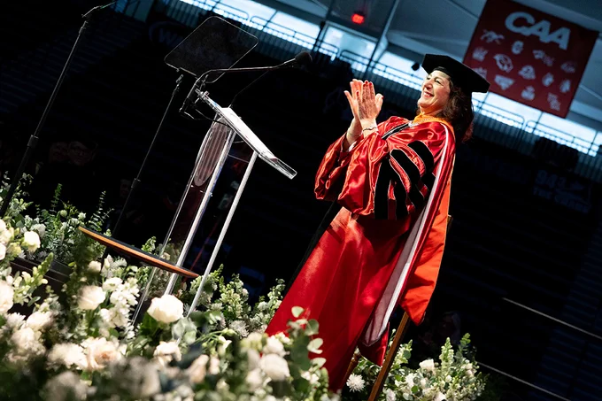 President Andrea Goldsmith stands at a podium in academic regalia during her inauguration ceremony.