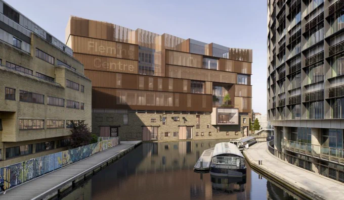 Modern brown and beige building labeled Fleming Centre beside a calm canal with boats docked along the waterway.