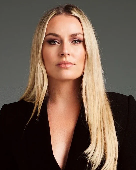 Lindsey Vonn in a black blazer in front of a gray background.